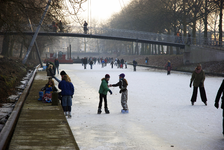 900013 Afbeelding van schaatsers op de bevroren Stadsbuitengracht te Utrecht, met op de achtergrond de St. Martinusbrug.